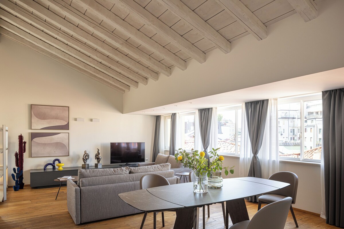 Una sala de estar moderna con sofá, mesa de comedor y televisor.