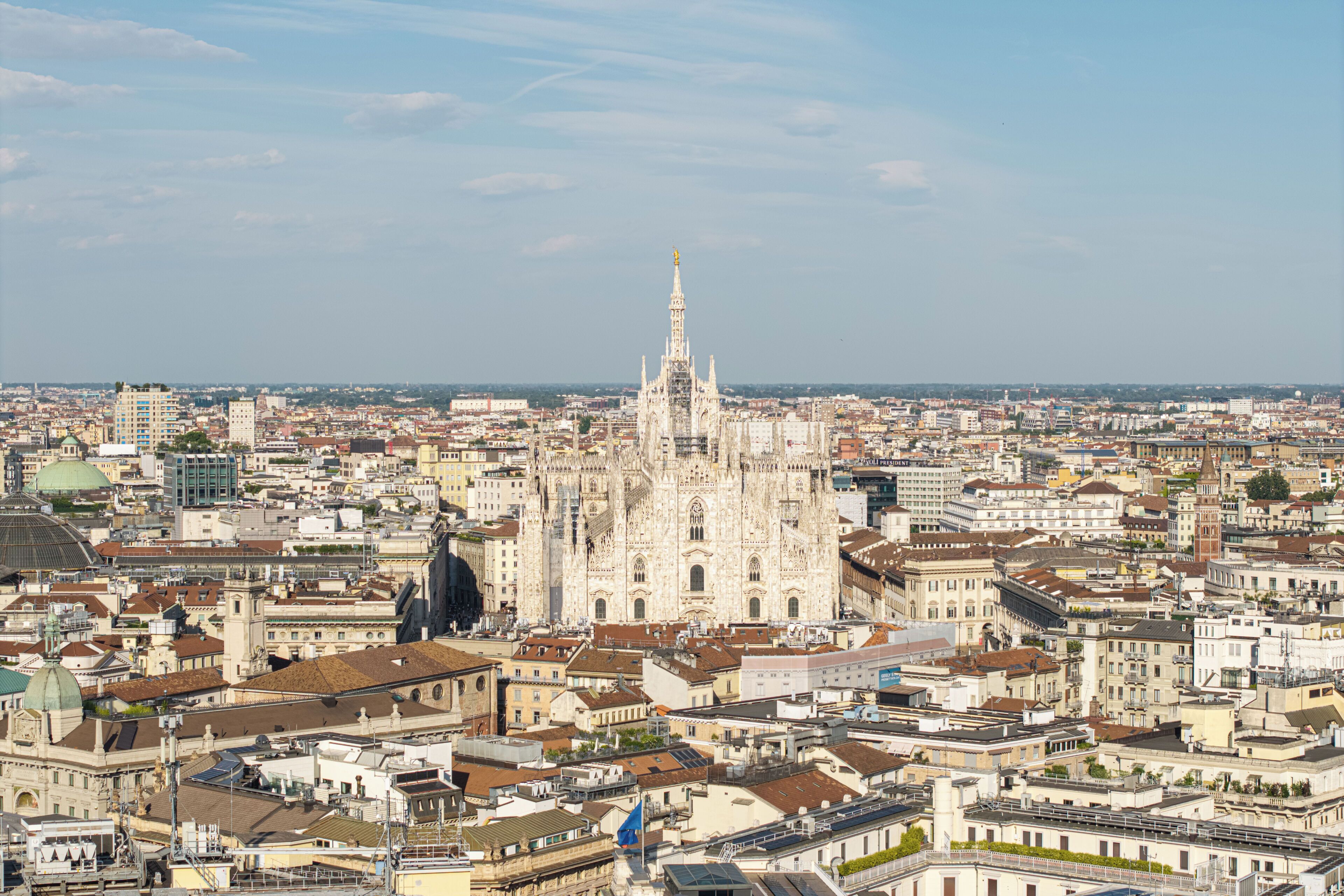 A cityscape with a prominent cathedral in the center, surrounded by dense urban buildings.