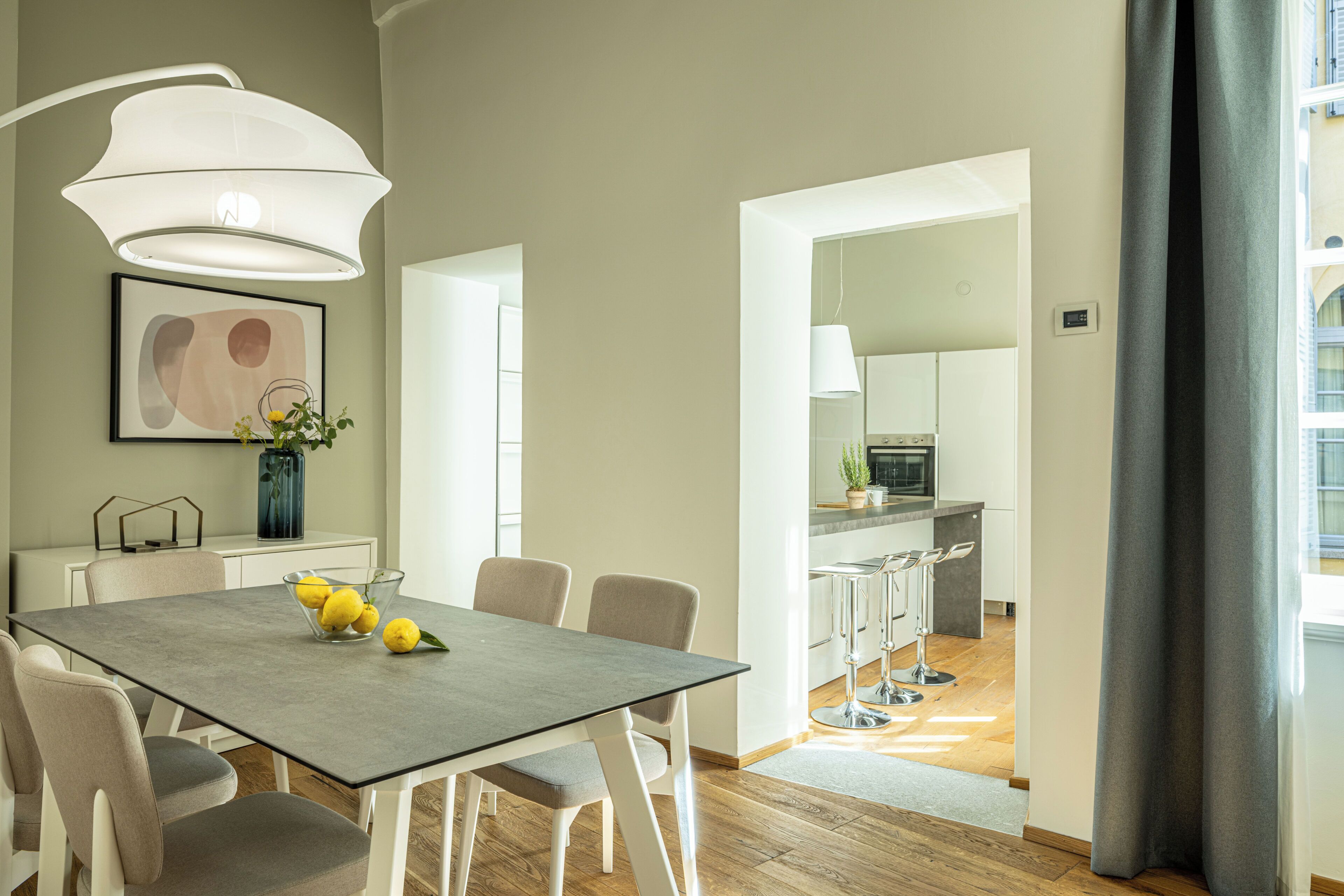 Una cocina moderna con horno empotrado y comedor con mesa y sillas.