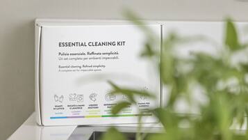 Una confezione bianca di kit pulizia essenziale con testo e icone in italiano per guanti, detersivo per bucato, detergente multiuso, sapone per bucato, spugna e panno.