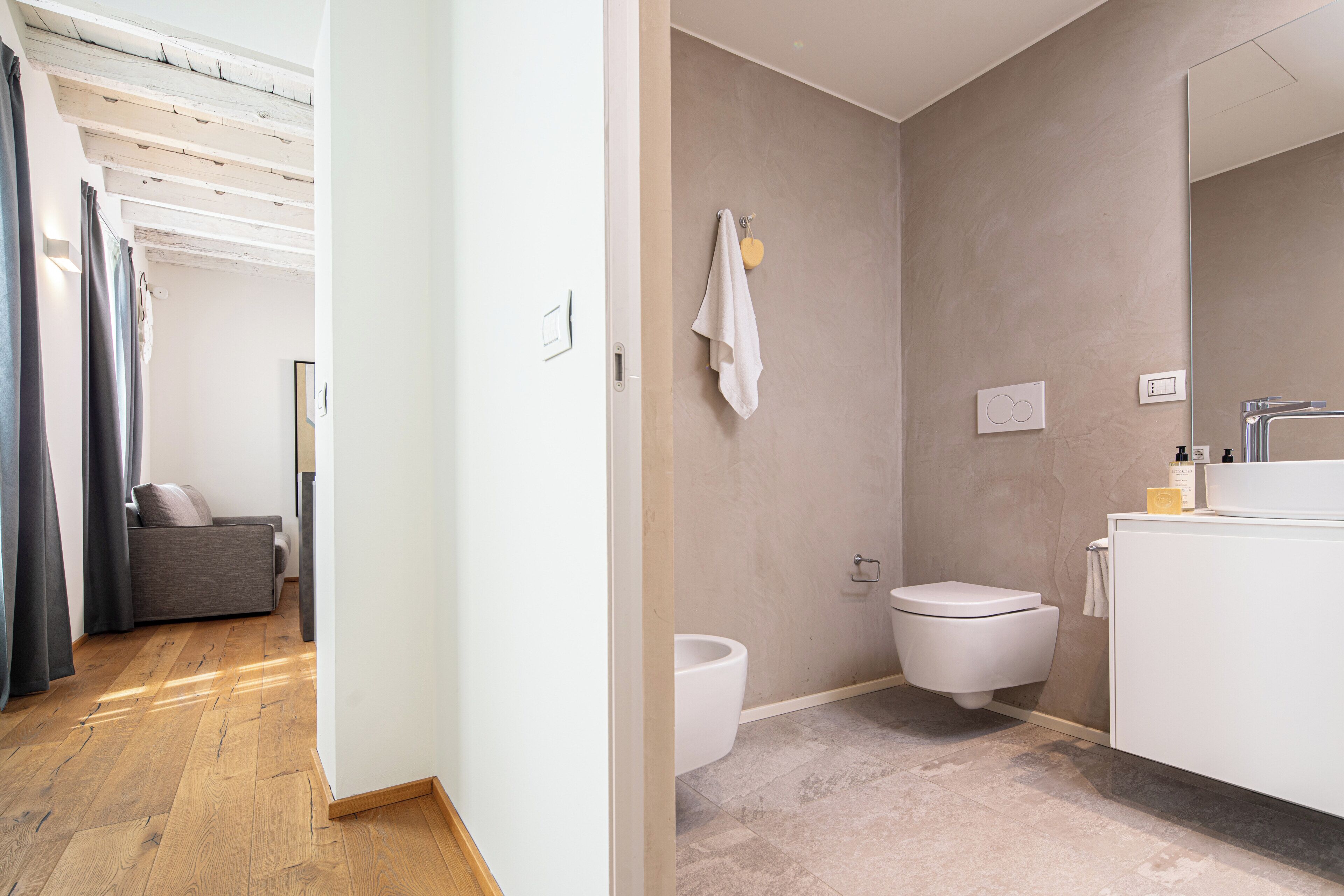 Un baño moderno con inodoro, lavamanos y zona de ducha.