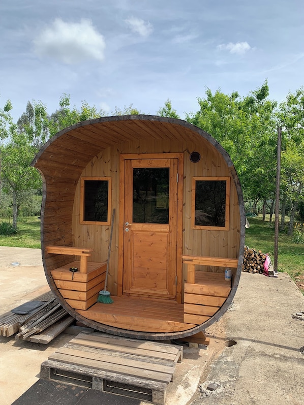 A wooden cabin with a curved roof, a door, and two windows.