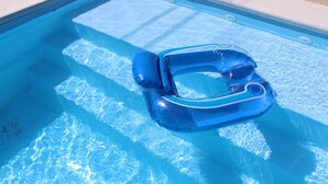 A clear blue swimming pool with a blue inflatable ring.