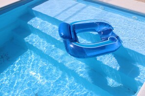 Une piscine d’eau claire et bleue avec un flotteur gonflable bleu.