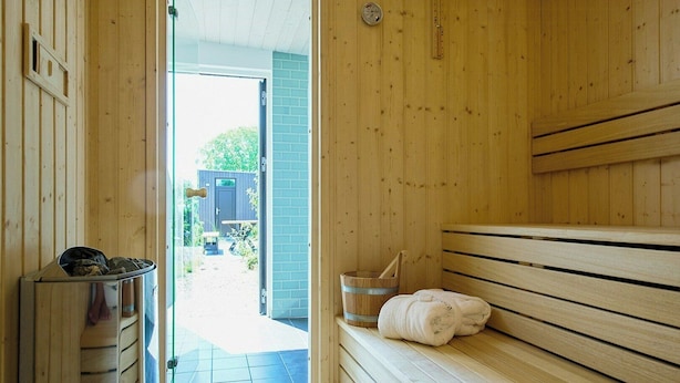 Un sauna avec des bancs en bois, une serviette et un seau.