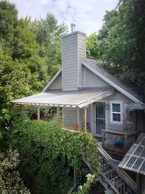 Ein Haus mit Veranda, Schornstein und einer Terrasse.