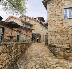 A narrow stone pathway between buildings with stone walls and traditional architecture. - Casa do Rio - Quinta do Moinho Apartment with Mountain View, Wi-Fi and Air Conditioning (Faia)