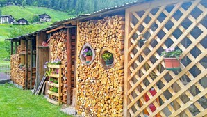 Un edificio rustico con facciata in legno, una finestra a griglia e un'apertura che conduce all'interno.
