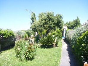A pathway through a garden with various plants and trees. - Holiday Home 'Mas Iles Des Pecheurs' with Sea View, Shared Pool and Wi-Fi (Le Barcarès)