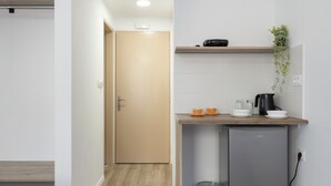 A compact kitchenette with a refrigerator, a coffee maker, and a small countertop. - Room 'Double  3' with Private Terrace, Wi-Fi and Air Conditioning (Ano Symi)