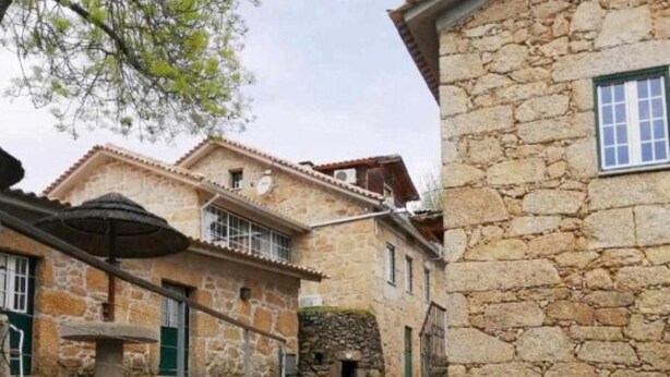 A narrow stone pathway between buildings with stone walls and traditional architecture.