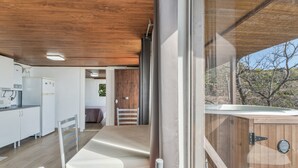 A modern kitchen with a wooden ceiling, a dining area with a table and chairs, and a view of the desert landscape through large windows. - Vacation Home 'Karla' with Sea View, Shared Pool and Wi-Fi (Cruz de Tea)