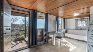 A modern interior with a dining area, a sofa, and a view through large windows. - Vacation Home 'Karla' with Sea View, Shared Pool and Wi-Fi (Cruz de Tea)