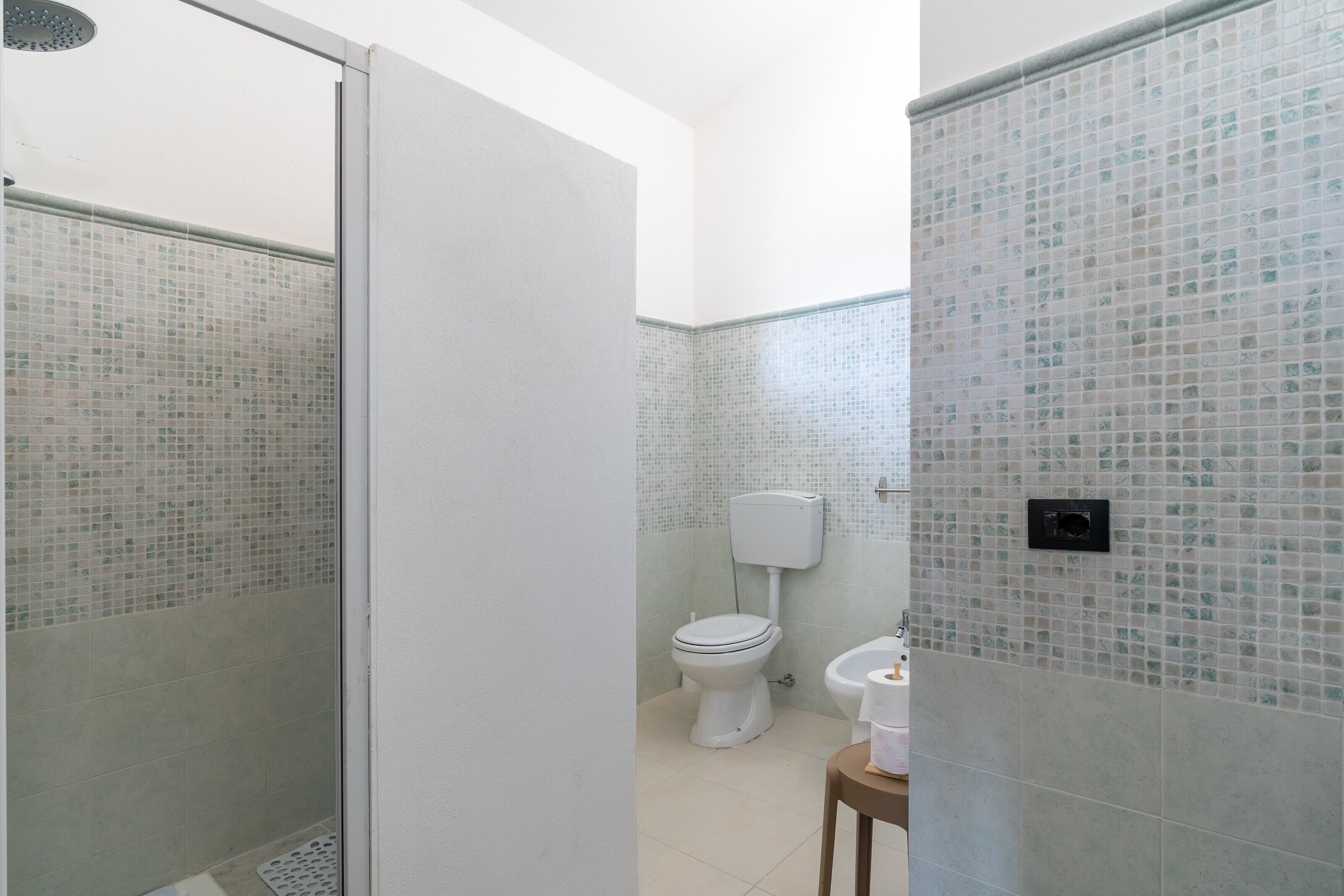 Ein Badezimmer mit Dusche, Toilette und Bidet.