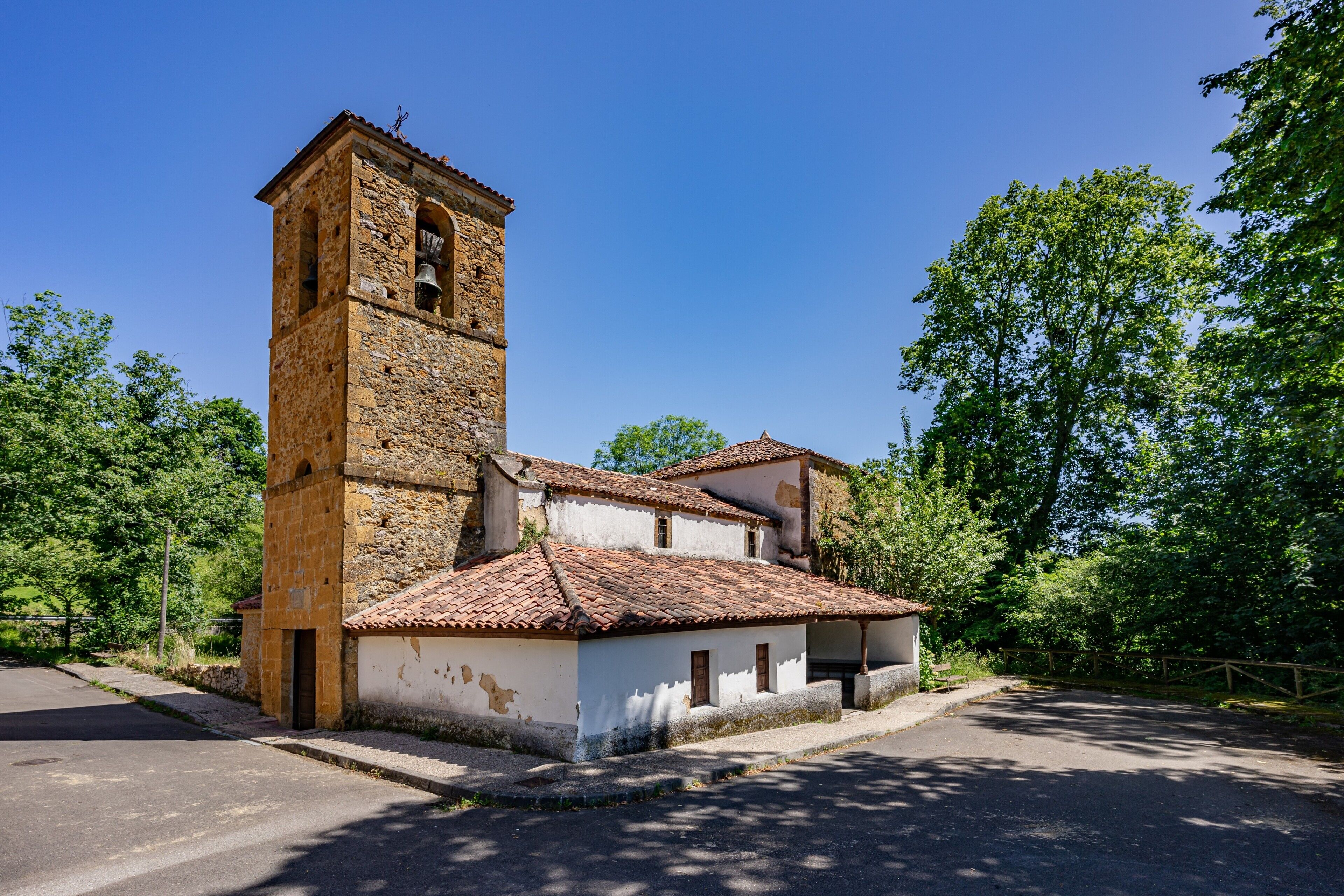 Un edificio histórico con una torre de campanas, un patio interior y un camino adoquinado.