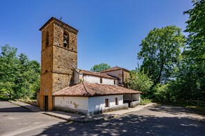 Ein historisches Gebäude mit einem Glockenturm, einem Innenhof und einer gepflasterten Straße.