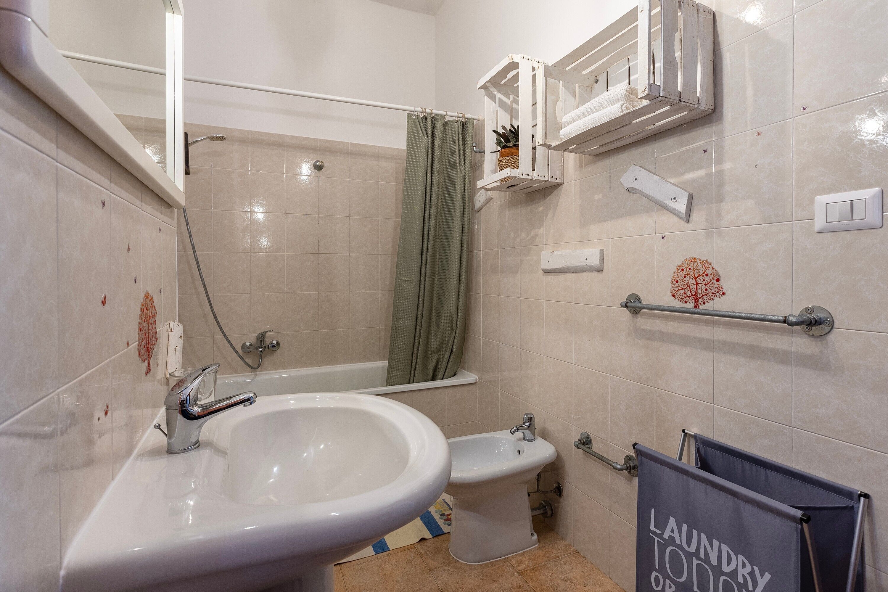 A bathroom with a sink, bidet, and shower.