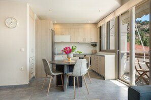 Une cuisine moderne avec une table à manger, des chaises et un vase de fleurs.