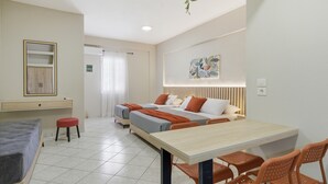 A hotel room with a bed, a desk, a chair, a small stool, and a wall-mounted shelf. - Studio Apartment '6' with Shared Garden, Wi-Fi and Air Conditioning (Syvota)