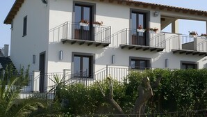 A multi-story building with balconies, windows, and a staircase.