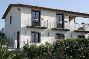 A multi-story building with balconies, windows, and a staircase. - 'Calura' Room with Garden View, Wi-Fi and Air Conditioning (Mazzarino)