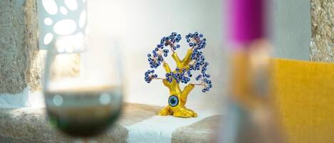 A table with a decorative golden tree sculpture, a candle, and a glass of wine.