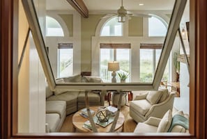 Ein modernes Wohnzimmer mit Glasdecke, einer Couch, einem Couchtisch und einer Lampe.