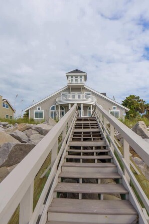 Ein mehrgeschossiges Haus mit einer Treppe, die zu einem Balkon führt.