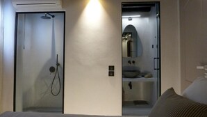 A modern bathroom with a glass shower enclosure, a large mirror, and a sink. - Villa 11.7 – Luxus über dem Elia Beach, Mykonos (Elia)