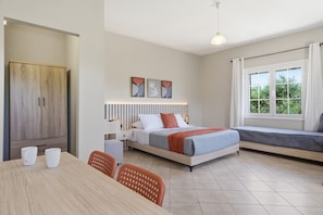A bedroom with a bed, bedside table, and a window with curtains. - Studio Apartment '4' with Mountain View, Wi-Fi and Air Conditioning (Syvota)