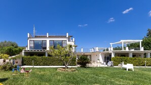 A modern two-story house with a balcony, a covered patio, and a well-maintained lawn. - Lustru Room with Mountain View, Wi-Fi, and Air Conditioning (Mazzarino)