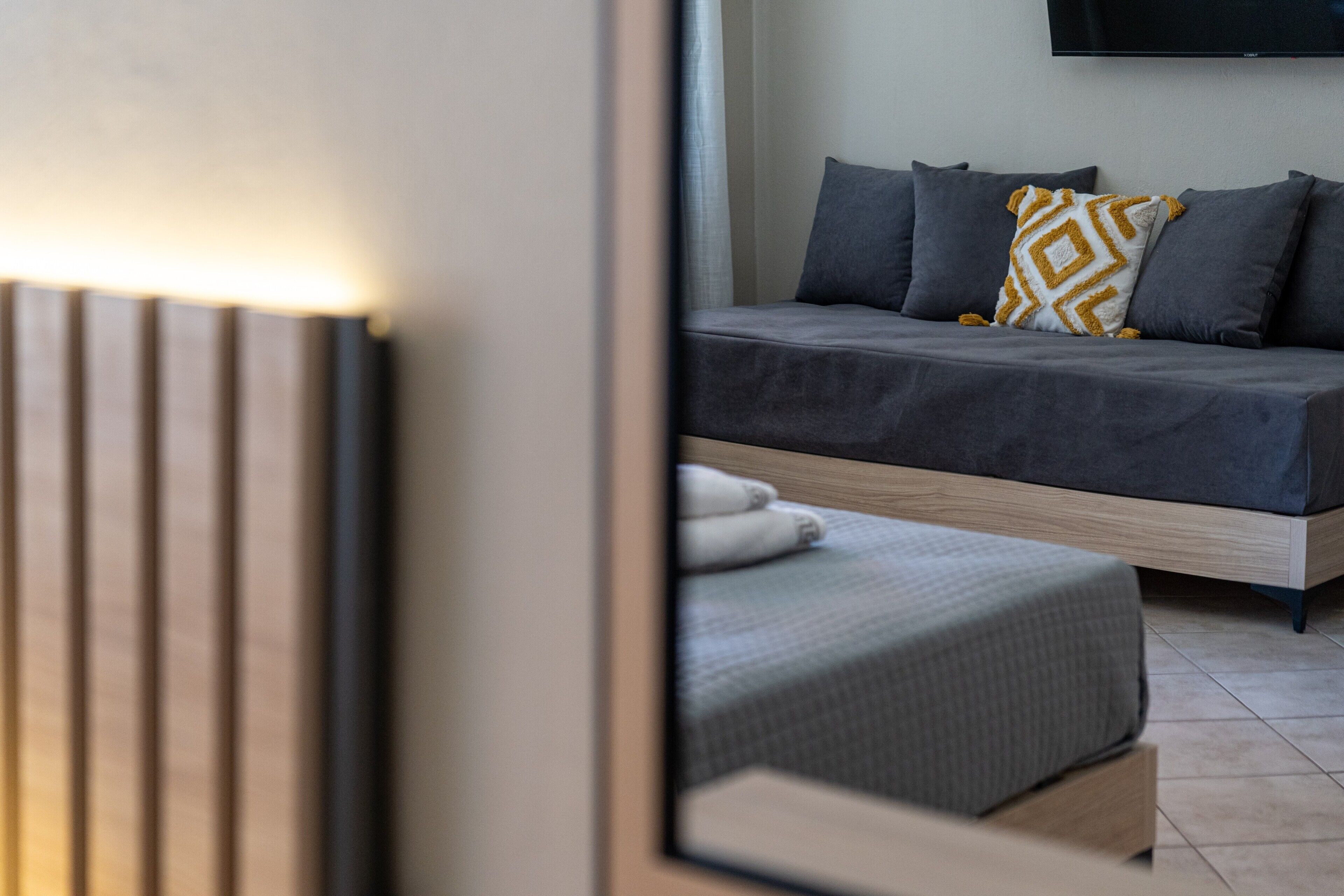 Ein modernes Schlafzimmer mit einem Bett, Kissen und einem Nachttisch.
