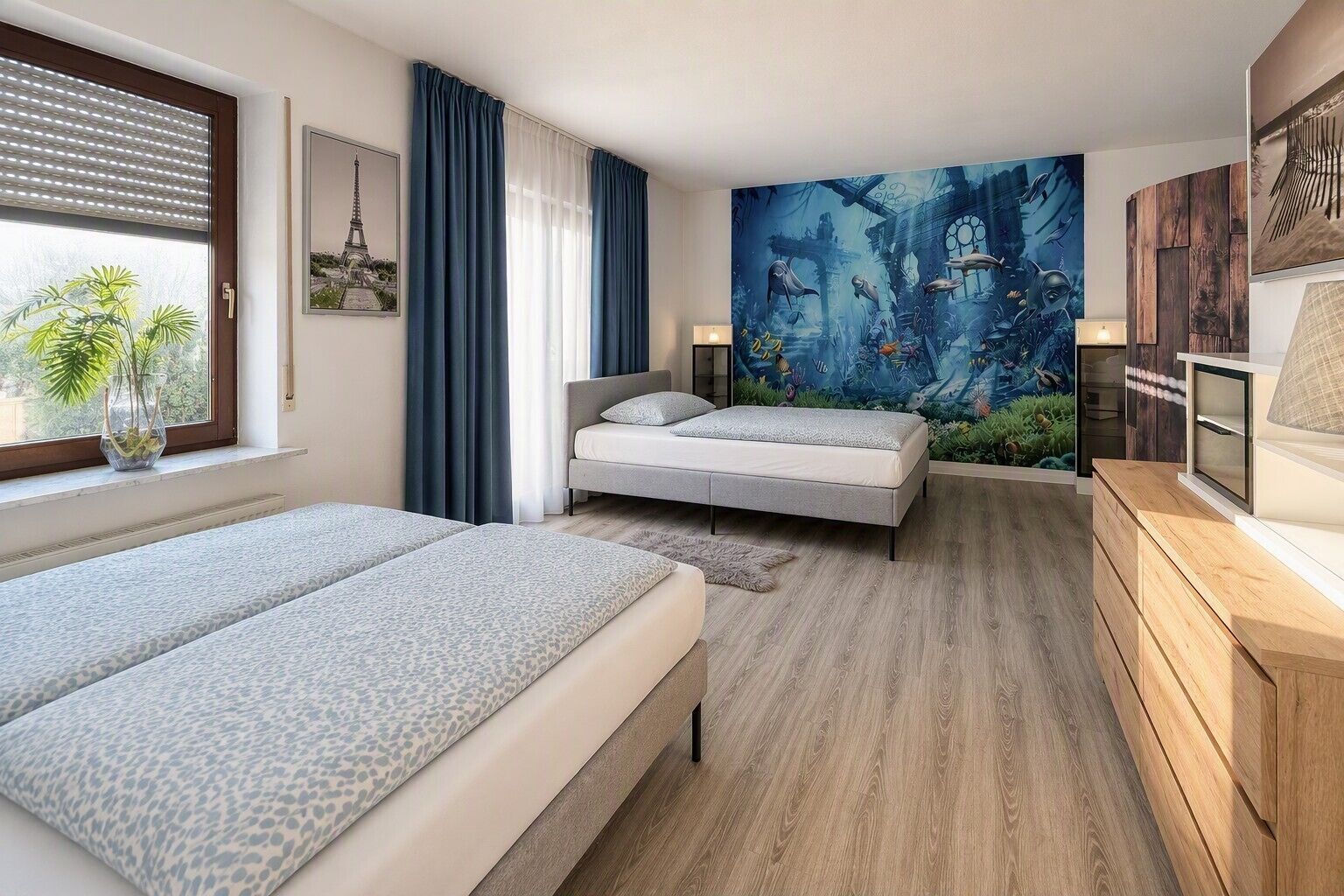 Une chambre moderne avec un lit, un banc, une fresque murale et une fenêtre avec des rideaux.