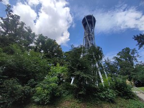 A tall tower with a unique architectural design surrounded by dense greenery. - Modern, Bright Tiny House Surrounded by Vineyards and Nature (Efringen-Kirchen)