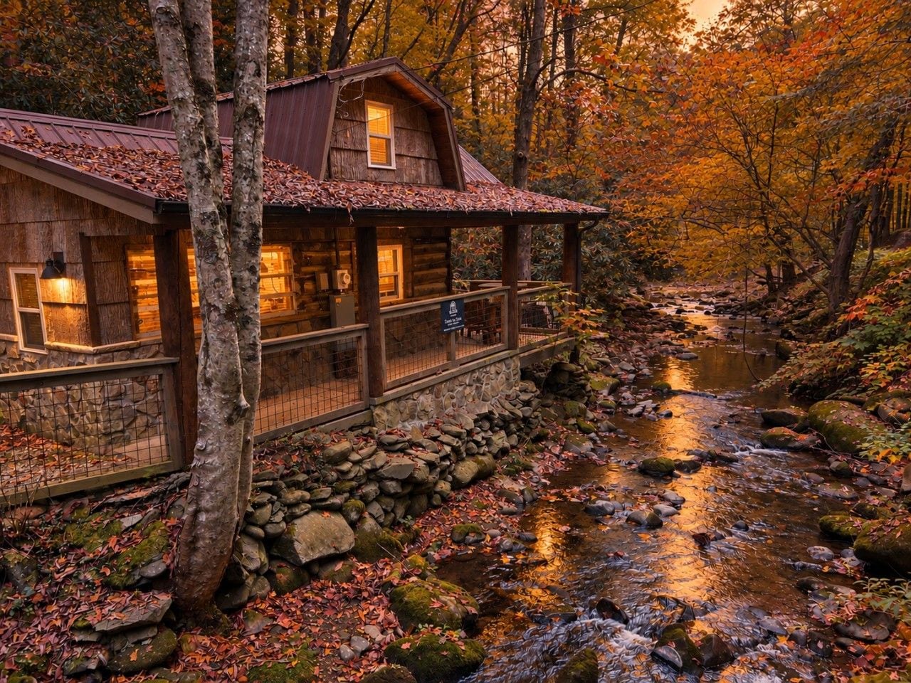 Une cabane rustique avec des fondations en pierre, des murs en bois et une véranda donnant sur un ruisseau.