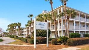 A multi-story hotel with a sign reading 'Grand Caribbean East.' - Grand Caribbean East 112- Crystal Blu (Destin)