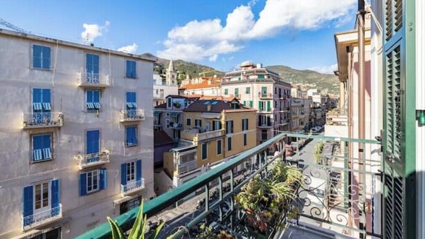 Un edificio a più piani con balconi, affaccio sulla strada e cielo sereno.