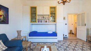 Una stanza con un letto, una libreria, un lampadario e un pavimento decorato.