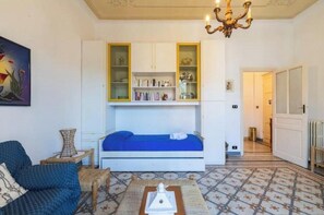 Una stanza con un letto, una libreria, un lampadario e un pavimento decorato.
