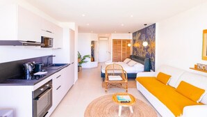 Un apartamento moderno con cocina, sala de estar y dormitorio.
