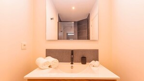 A bathroom with a double sink, a mirror, and towels. - DDL 623, sea view, serenity and comfort (Anse Marcel)