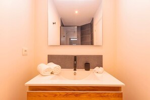Ein Badezimmer mit einem Waschbecken, einem Spiegel und Handtüchern.