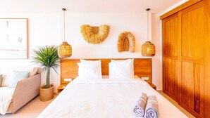 A bedroom with a wooden headboard, white bedding, a potted plant, and a large wooden wardrobe. - DDL 623, sea view, serenity and comfort (Anse Marcel)