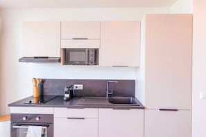A modern kitchen with a microwave, stove, and sink. - DDL 624, sea view, beach front, serenity and comfort (Anse Marcel)