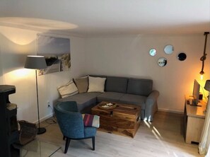 A modern living room with a sofa, armchair, coffee table, and a desk with a computer. - Apartment 'Westkate' with Sea View, Private Terrace and Wi-Fi (Hohwacht (Ostsee))