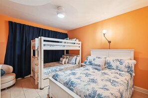 A room with a bunk bed, a bedside table, a lamp, and a chair. - Jade East 130- Jade Gem (Destin)
