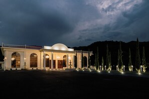 A large, well-lit building with a symmetrical facade, multiple arched windows, and a central dome. - catleya royal club (Pereira)