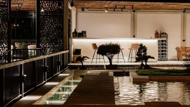 A pool area with a bar, seating, and a decorative fence. - catleya royal club (Pereira)