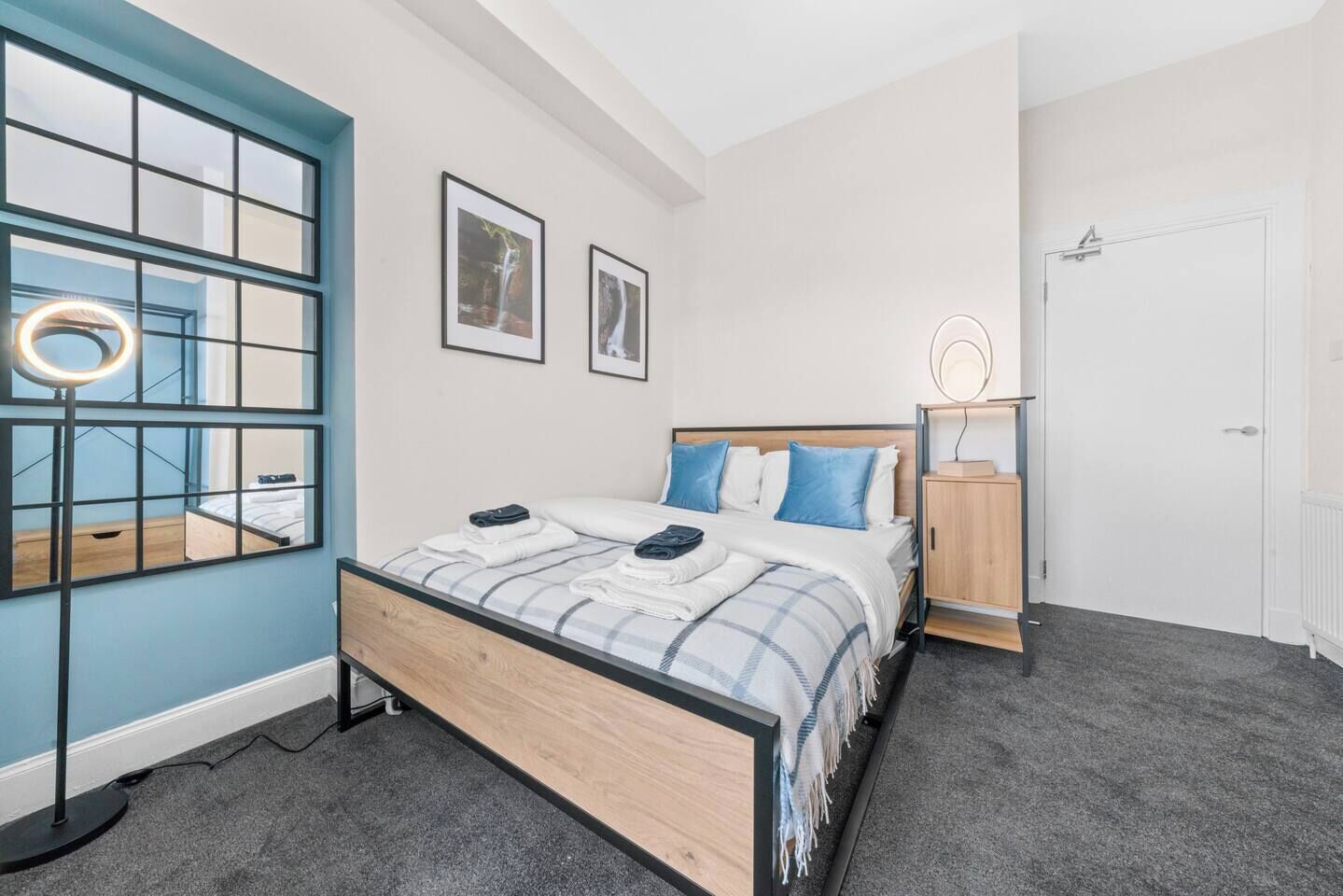 Une chambre à coucher comprenant un lit, une table de chevet, une armoire et une fenêtre donnant sur une cascade.