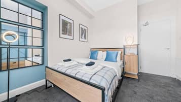 Une chambre à coucher comprenant un lit, une table de chevet, une armoire et une fenêtre donnant sur une cascade.